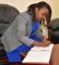 Amb. Emma Ng'ang'a signs the Visitors Book in the Director's office in Karen, Nairobi.